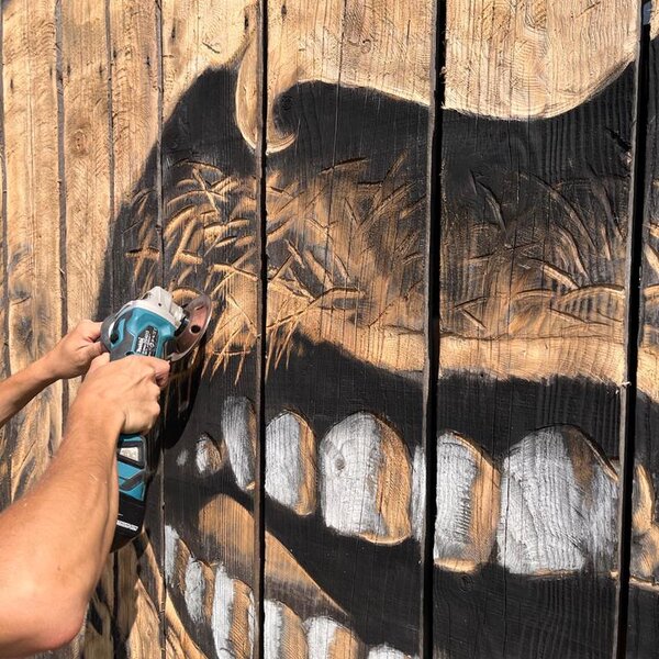 Un pittore esegue un'opera di street barch in primiero