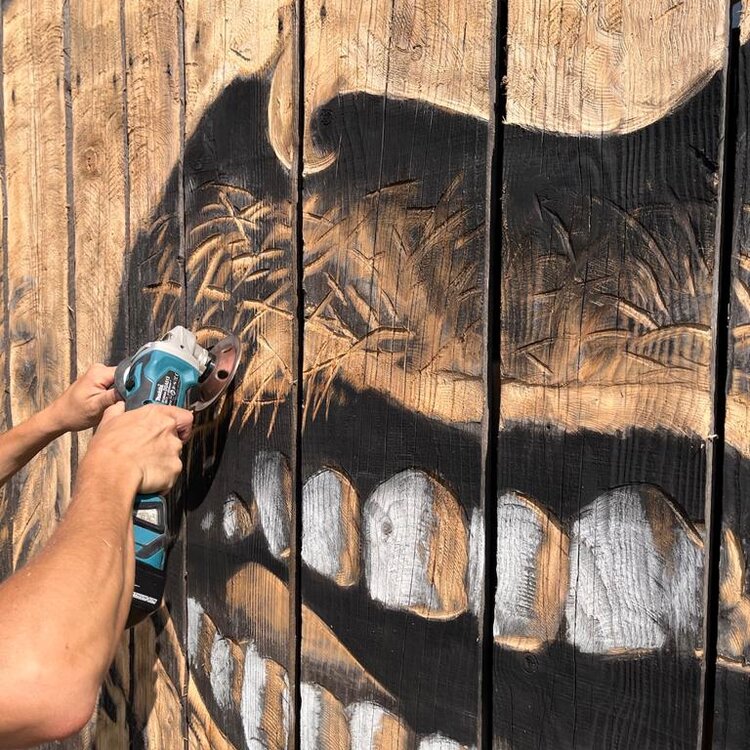 Un pittore esegue un'opera di street barch in primiero