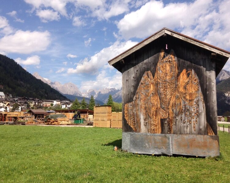 Opera di street barch in Primiero: pesci sul legno di un maso