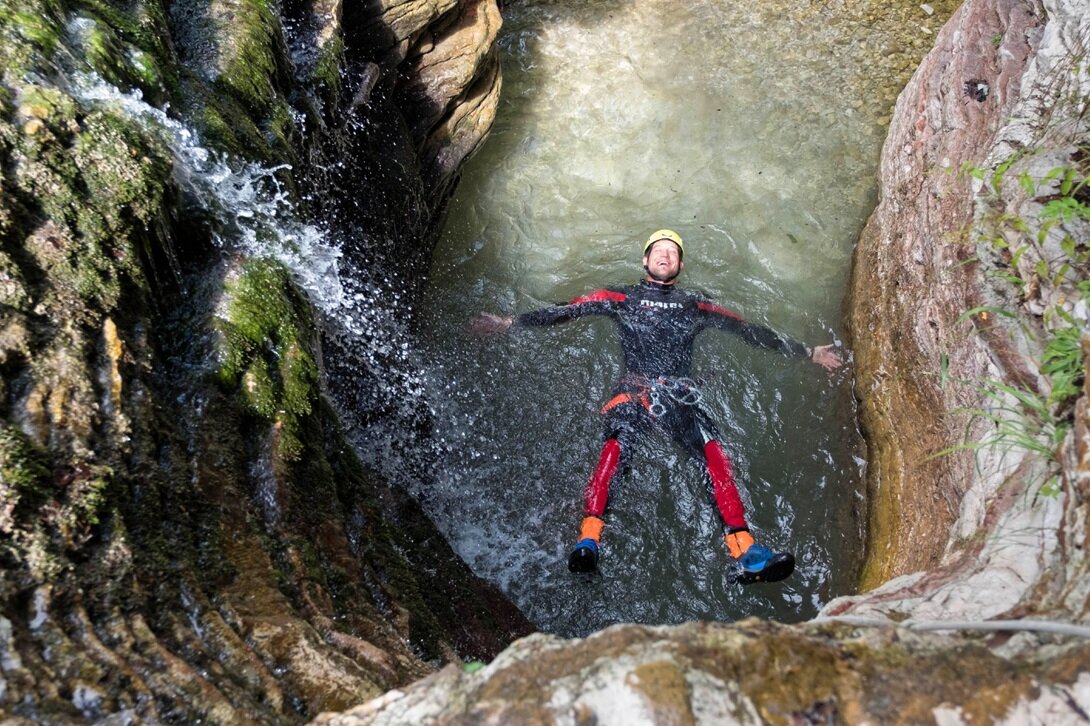 Un ragazzo si diverte facendo canyoning in Primiero