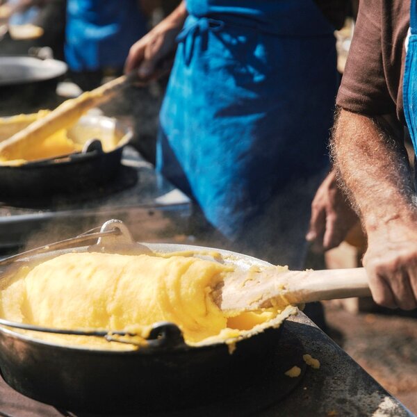 Proloco prepara la polenta nella desmontegada