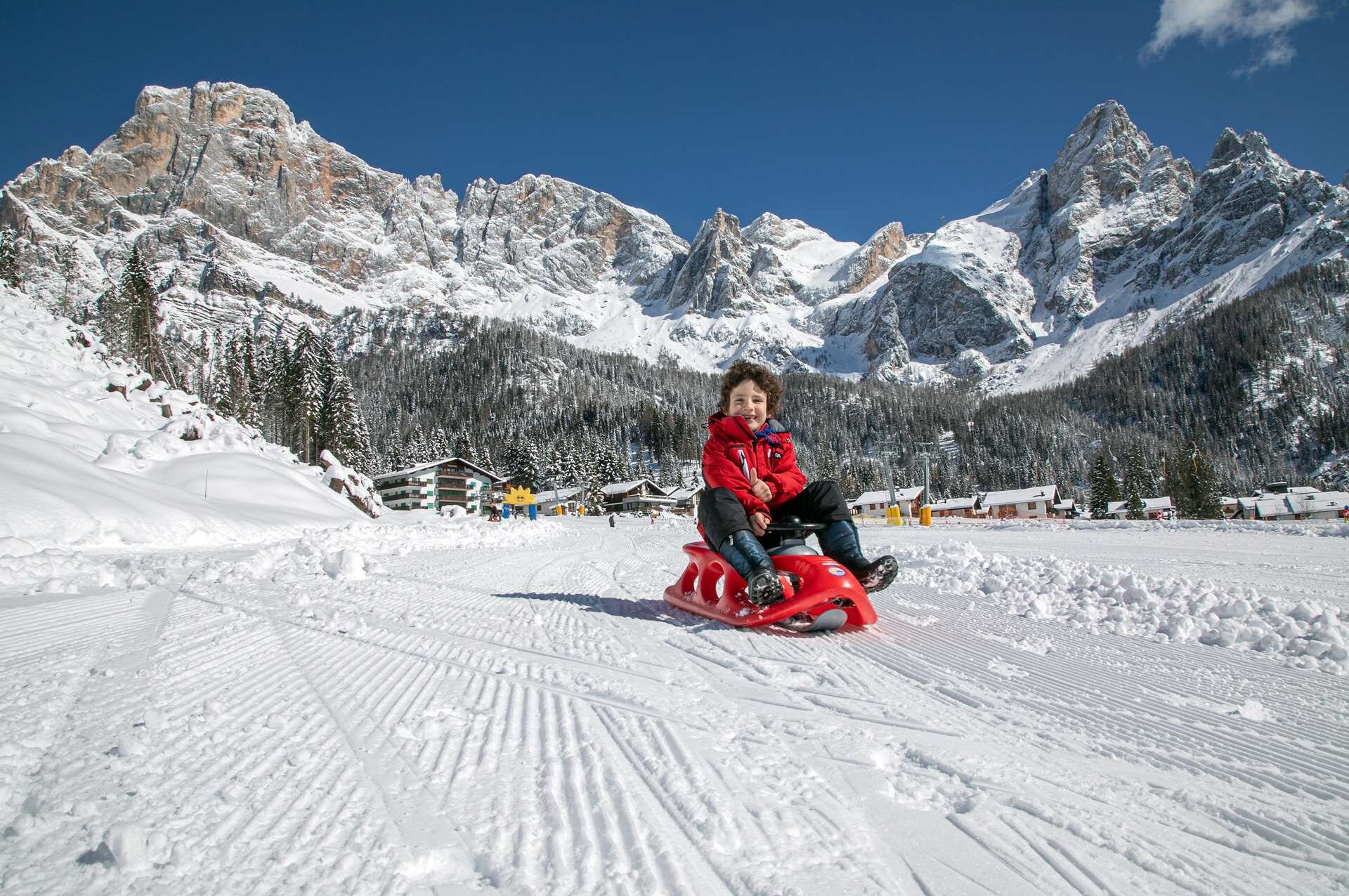 Bambini su bob in un parco sulla neve a Primiero