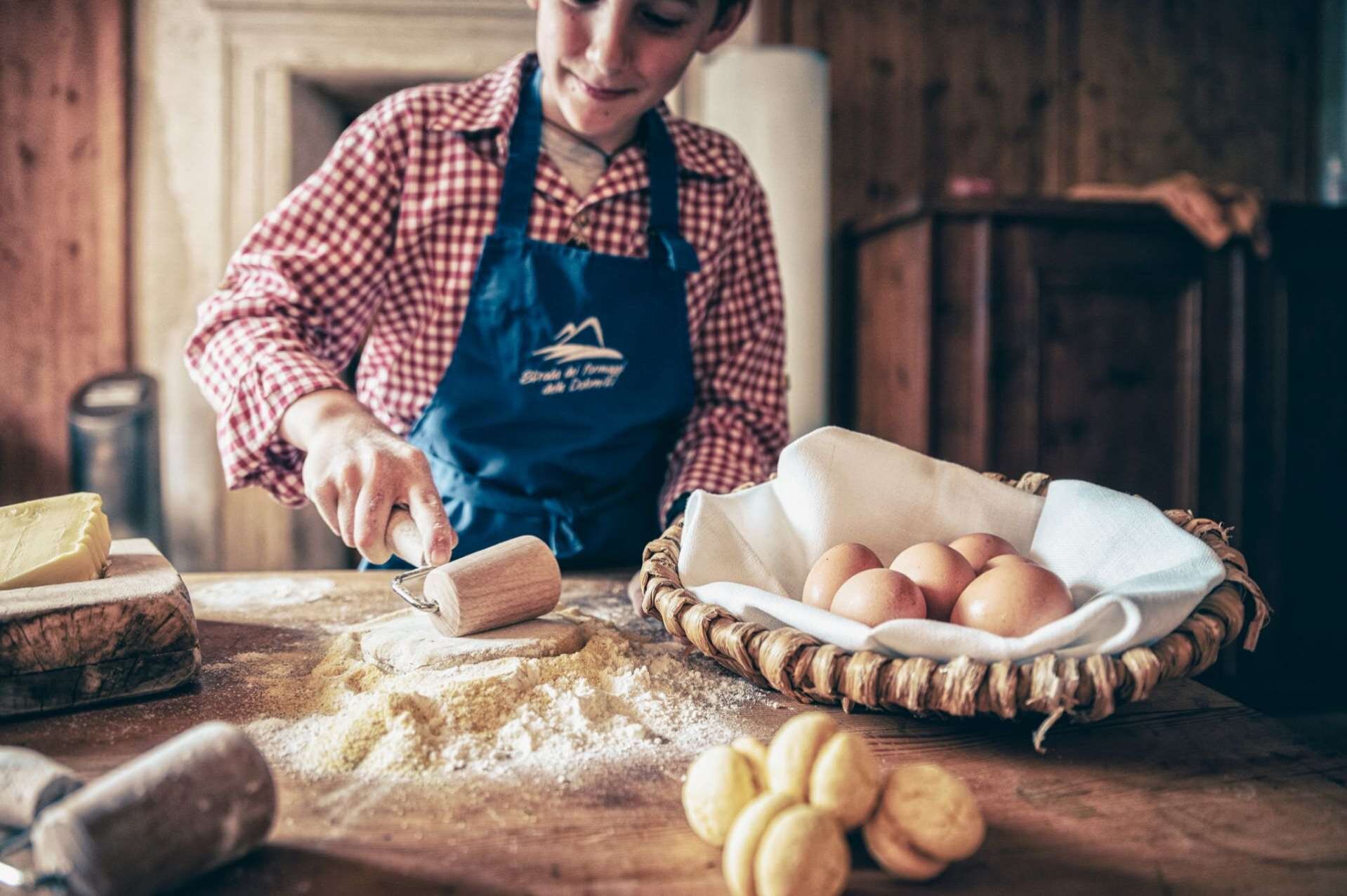Bambino cucina con le uova e la farina