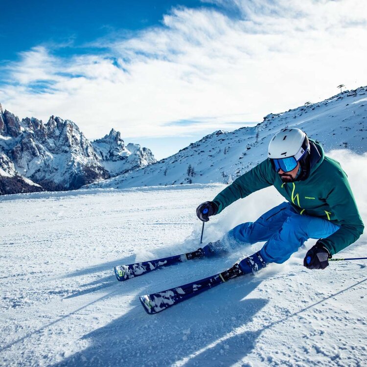 Sciatore scende sulle piste sci di San Martino di Castrozza