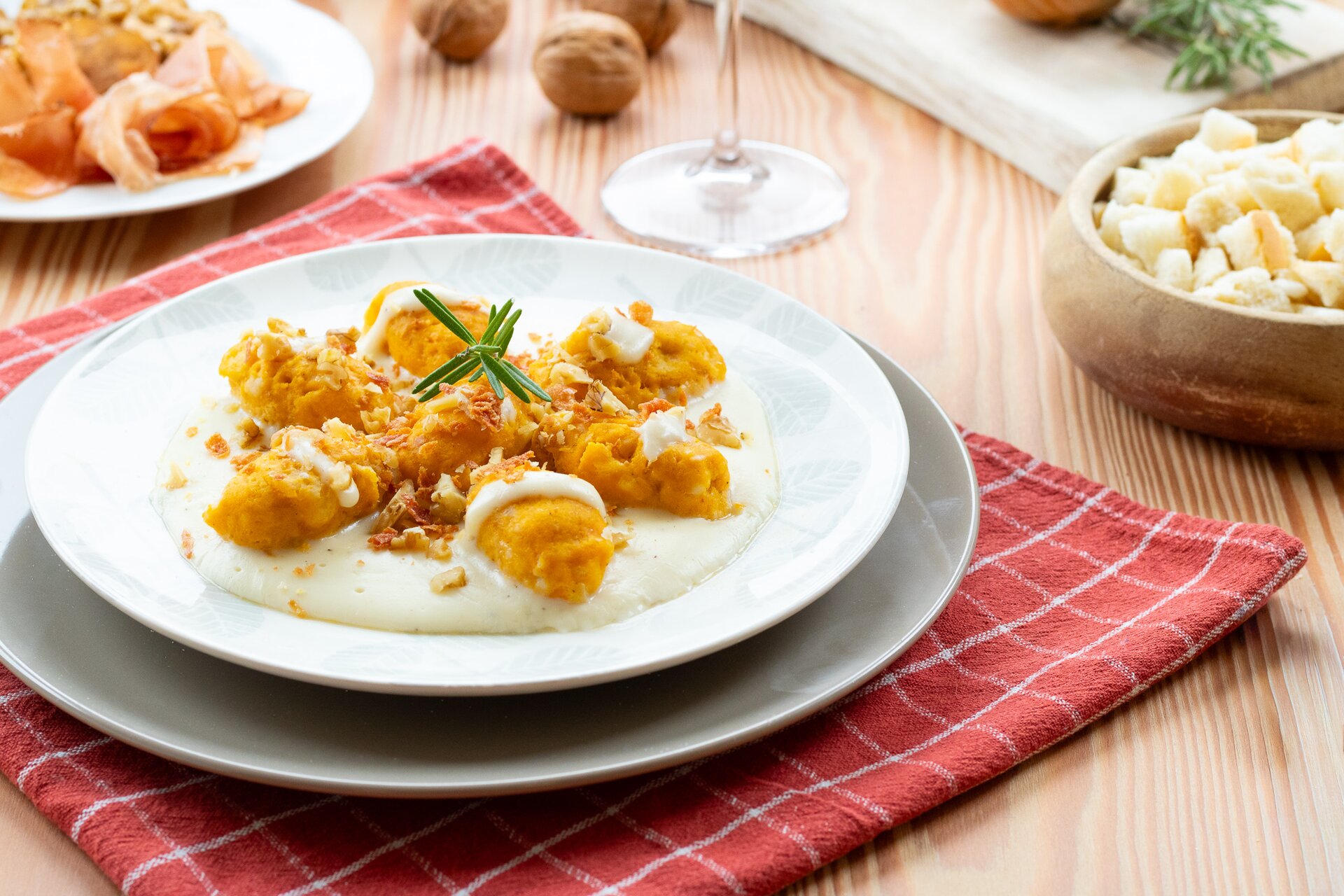 Strangolapreti di zucca su fonduta al Trentingrana, con speck croccante e noci