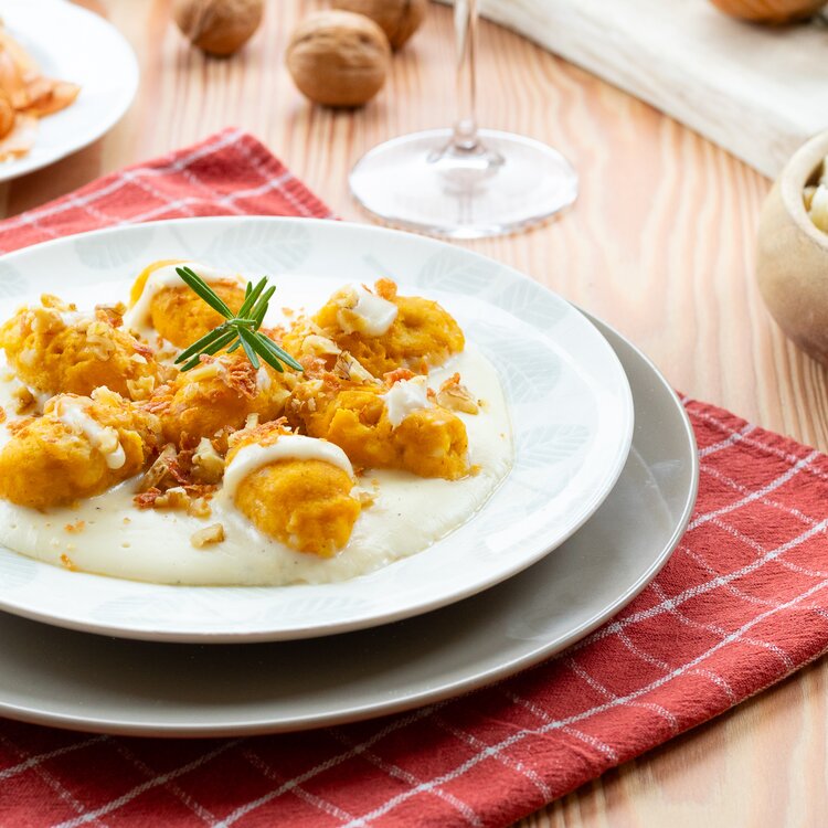 Strangolapreti di zucca su fonduta al Trentingrana, con speck croccante e noci